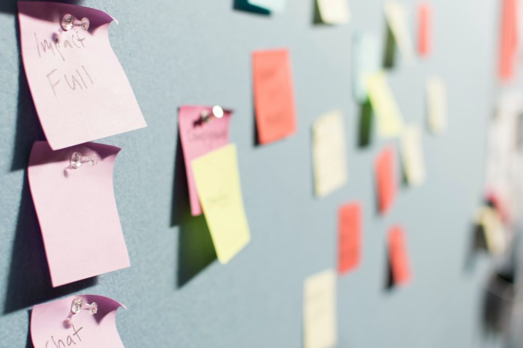 Photo of a wall covered in post it notes, each one representing a project label.